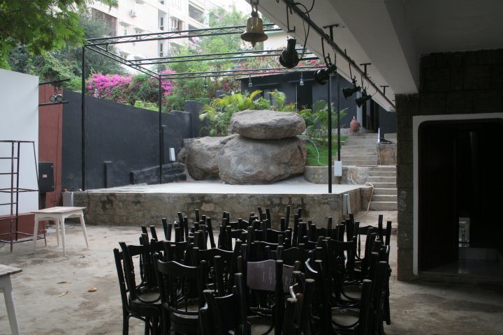 The empty open-air stage with its big rock, chairs stacked in front