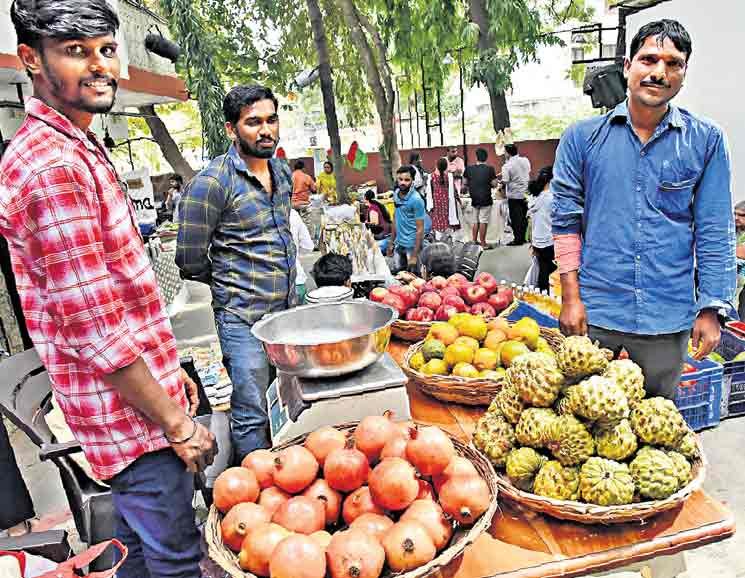 Farmers beside baskets of fruit